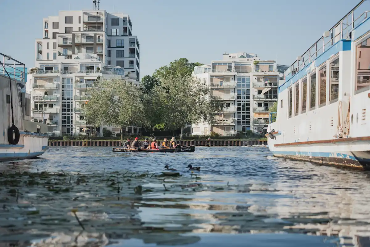 Teamevent Hellomed - Kanu auf der Spree vor Wohnhäusern