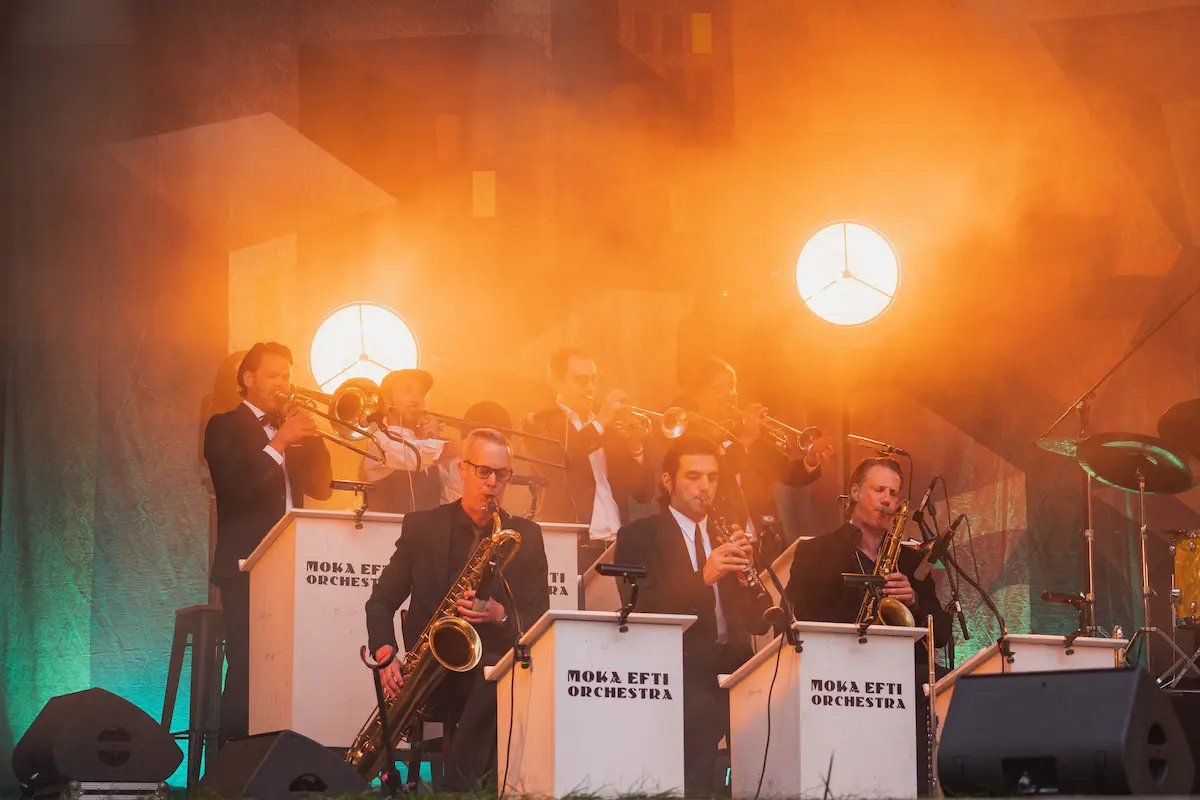 Moka Efti Orchestra - Bläsersatz im orangefarbenen Bühnenlicht