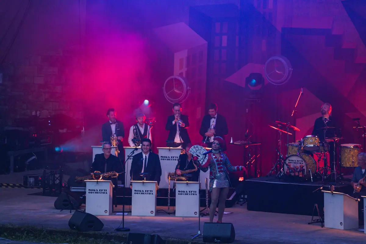 Moka Efti Orchestra mit Sängerin im blau-roten Bühnenlicht